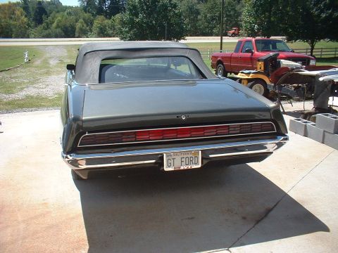 1970 Ford Torino - The rear of a convertible shows off its taillights and chrome bumper, with other vehicles visible in the background.
