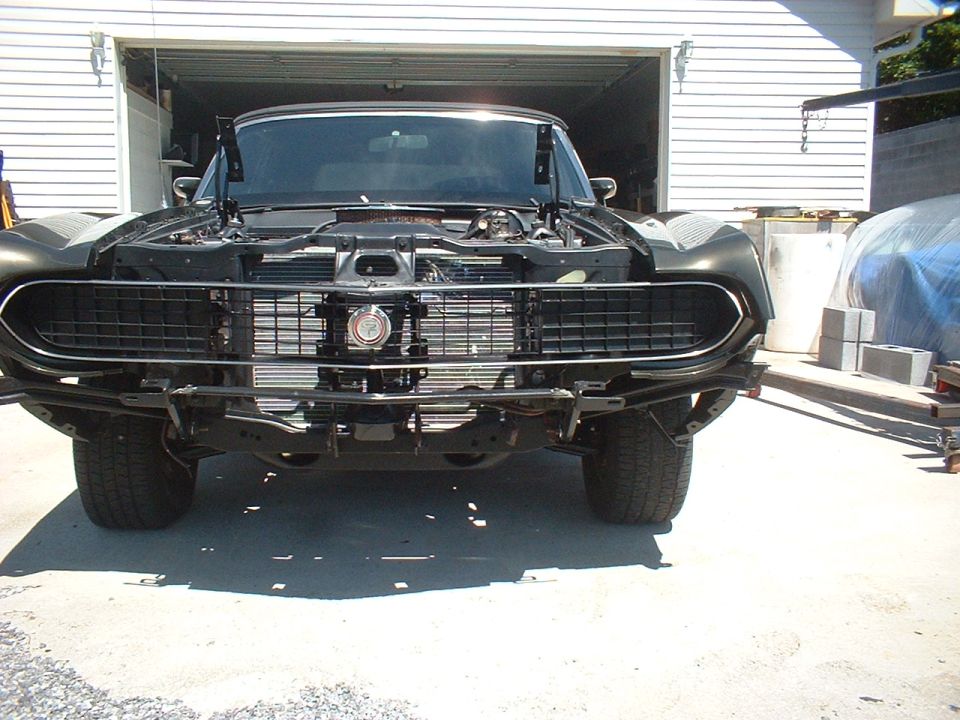 1970 Ford Torino front end, hood open, grille exposed, in front of a garage