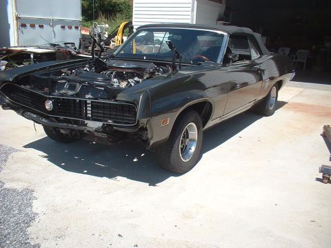 1970 Ford Torino - This 1970 Ford Torino convertible is parked outside with its hood up, revealing the engine bay.