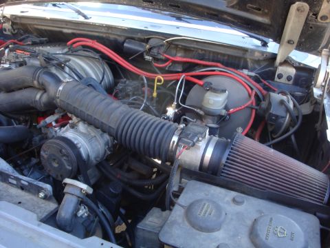 1989 Ford Bronco - Close-up view of a vehicle's engine bay, highlighting an upgraded air intake system and various engine components.