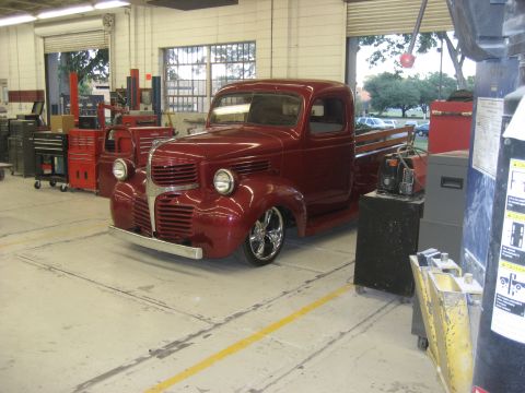 1978 Ford Bronco - A custom red pickup truck is parked inside a workshop with various tools and equipment visible.
