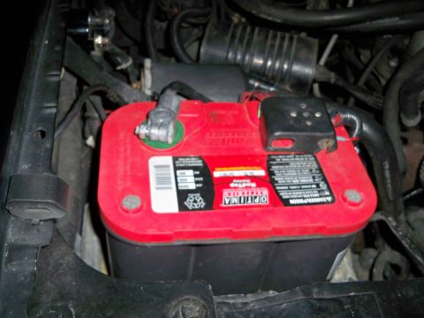 1995 Ford F-150 - Close-up of a red Optima battery installed in a vehicle's engine compartment.