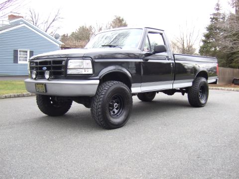 1995 Ford F-150 - This black 1995 Ford F-150 pickup truck is shown from a 3/4 front angle.