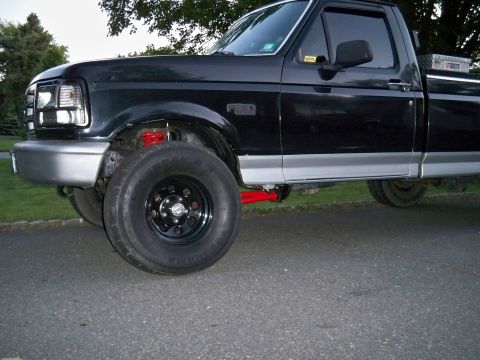 1995 Ford F-150 - Front quarter view of a black 1995 Ford F-150 pickup truck with silver trim and aftermarket wheels.