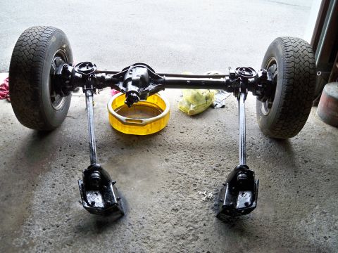 1995 Ford F-150 - A rear axle assembly with wheels and supporting components is shown on a concrete surface.