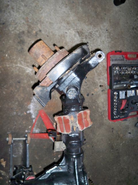 1995 Ford F-150 - A disassembled front axle assembly sits on a concrete floor next to a toolbox, suggesting a repair or rebuild process.
