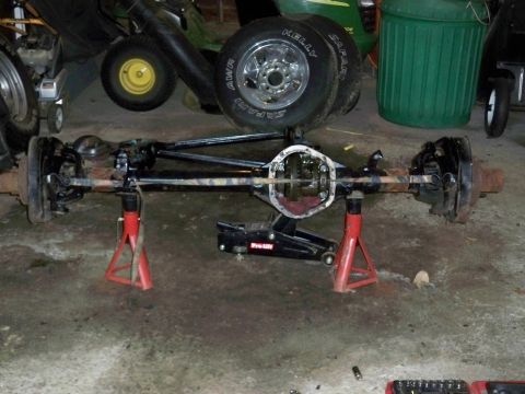 1995 Ford F-150 - A differential axle assembly is shown supported by jack stands and a jack, likely undergoing repair or rebuild.