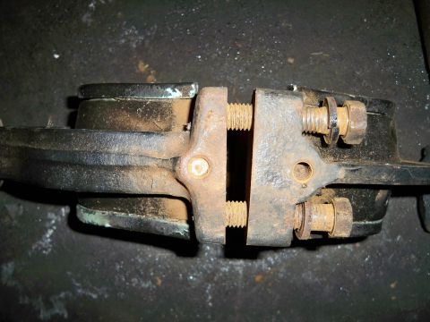 1995 Ford F-150 - A close-up view of a rusty brake caliper secured in a vise, indicating a repair or rebuild process.