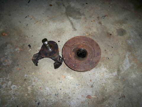 1995 Ford F-150 - Brake rotor and spindle assembly, likely from a truck, lying on a concrete surface.