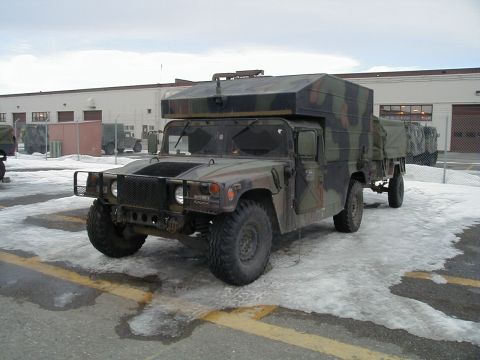 1998 Ford Crown Victoria - A military-style Humvee with a custom camper top is parked in a lot with snow on the ground.