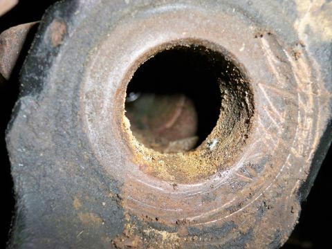 1995 Ford F-150 - Rusted metal part showing wear and tear, with visible circular markings on its surface.