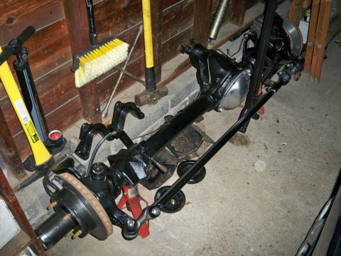 1995 Ford F-150 - A disassembled front axle assembly is shown supported by jack stands in a garage setting.