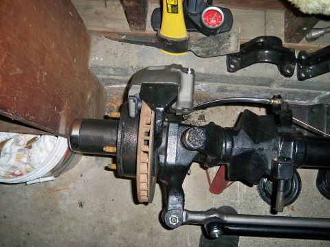 1995 Ford F-150 - Close-up of a vehicle's front axle assembly, showing the brake components and steering linkage.