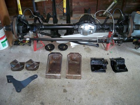 1995 Ford F-150 - Front axle and suspension parts for a Ford truck are laid out on the floor, ready for a rebuild.