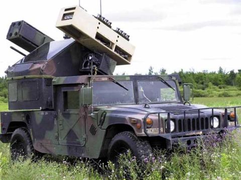 1998 Ford Crown Victoria - A military Humvee equipped with a TOW missile system sits in a field under a cloudy sky.