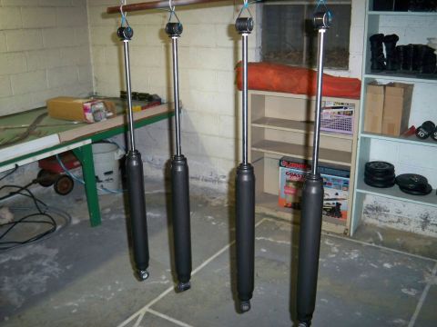 1995 Ford F-150 - Four shock absorbers are suspended and ready for installation or painting.