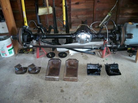 1995 Ford F-150 - A disassembled differential axle assembly is shown with associated parts laid out on the floor.