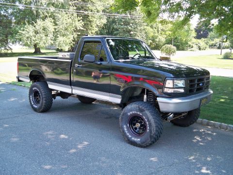 1995 Ford F-150 - This lifted pickup truck features a custom paint scheme and large off-road tires.
