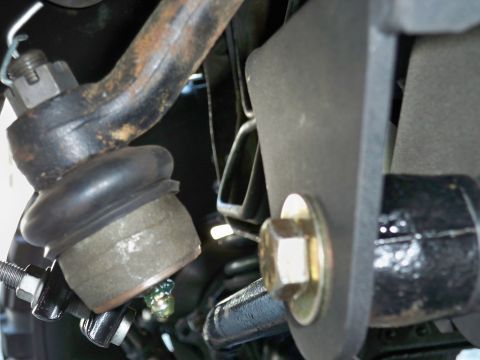 1995 Ford F-150 - This image shows a close-up view of the steering and suspension components of a vehicle, focusing on a ball joint and tie rod end.