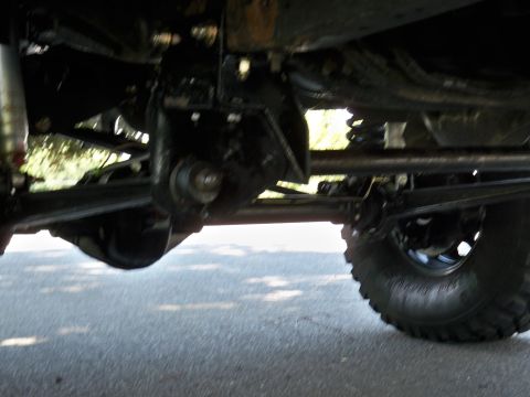 1995 Ford F-150 - The underside of a truck is shown, focusing on the suspension and axle components, with a tire visible on the right.