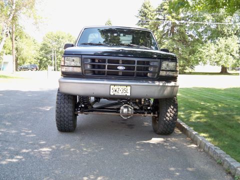 Black 1995 Ford F-150 front view with lifted suspension and aftermarket axle