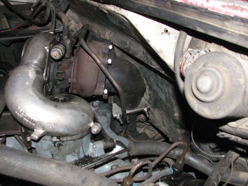 Turbocharger with intake piping and engine hoses visible