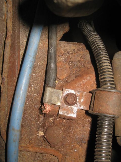 1981 Ford Bronco - Detail of corroded engine bay wiring and metal parts, with visible text on a cable.