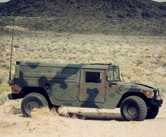 Camouflaged Humvee parked in a desert landscape