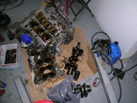 1995 Ford Probe - Engine components, including crankshafts and an oil filter, are laid out on the floor.