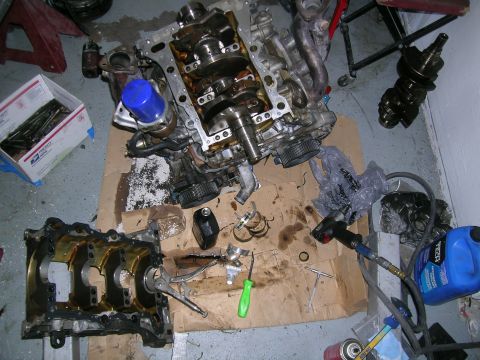 1995 Ford Probe - Engine components are laid out on a cardboard surface, suggesting a repair or rebuild process.
