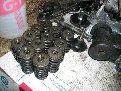 1995 Ford Probe - Engine valve springs and tools are laid out on a surface, possibly for repair or modification.