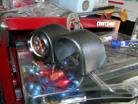 1995 Ford Probe - A black dual gauge pod with one gauge is shown, resting on a clear container filled with various fittings.
