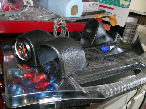 1995 Ford Probe - A collection of automotive gauges and fittings, including a gauge pod and red and blue AN fittings.