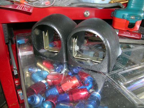 1995 Ford Probe - A collection of automotive gauge pods and assorted fittings are displayed on a workbench.