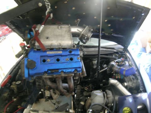 1995 Ford Probe - Engine installation in progress, showing a blue Mazda engine with turbo modifications.