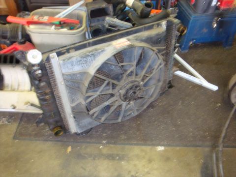 1989 Ford Bronco - A disassembled radiator and fan assembly is shown, with various hoses and parts scattered around.