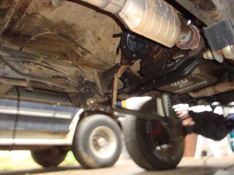 1989 Ford Bronco - A view from underneath a vehicle shows the exhaust system, transmission, and drive shaft.