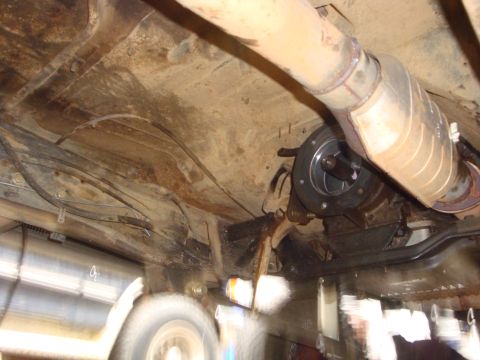 1989 Ford Bronco - Underside view of a vehicle's exhaust system and drivetrain components.
