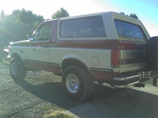 Ford Bronco parked outside, side and rear view. Two-tone paint with red and white