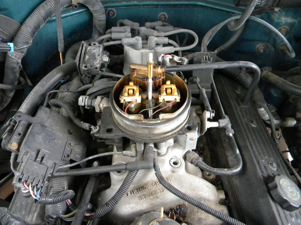 Close-up of a V8 engine's carburetor and distributor cap with wiring