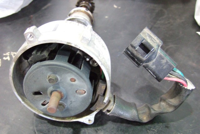 Used automotive distributor with wiring harness and connector on workbench