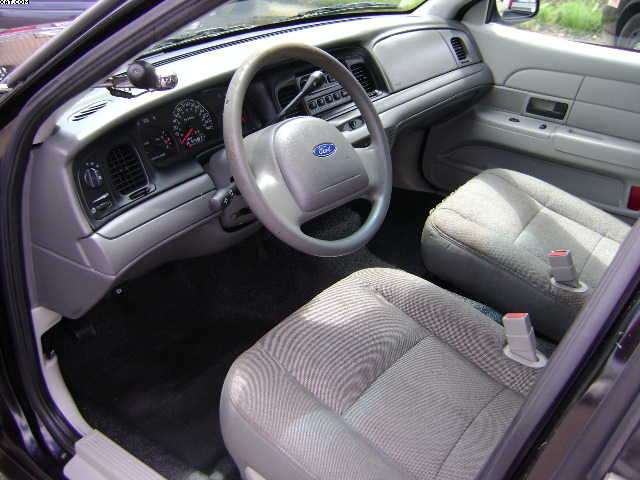 Interior view of a 2003 Ford Crown Victoria, showing the dashboard, steering wheel, and front seats