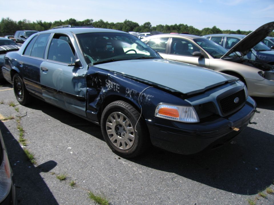 Two-tone sedan with front-end damage and "STATE POLICE" text visible