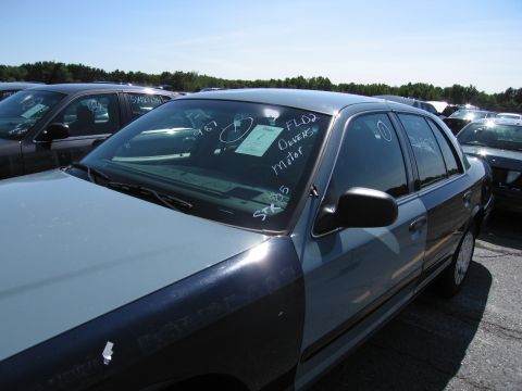 1991 Ford LTD Crown Victoria - A two-tone blue and gray 1991 Ford Crown Victoria LTD sedan is parked in a lot with other vehicles under a clear blue sky.