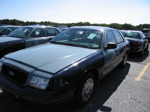 1991 Ford LTD Crown Victoria - A two-tone Ford Crown Victoria sits in a lot with other vehicles, its windshield covered in handwritten notes.