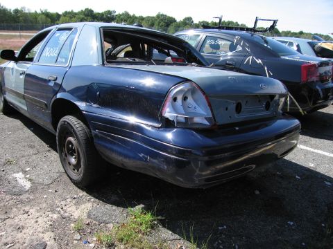 1991 Ford LTD Crown Victoria - This damaged Ford Crown Victoria is missing its rear bumper and taillights, with another vehicle visible behind it.