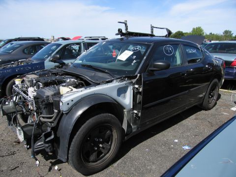 1991 Ford LTD Crown Victoria - Junkyard scene with a damaged black sedan and other vehicles.