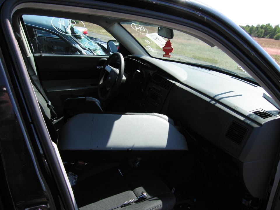Car interior with a broken windshield, a red air freshener, and a gray center console