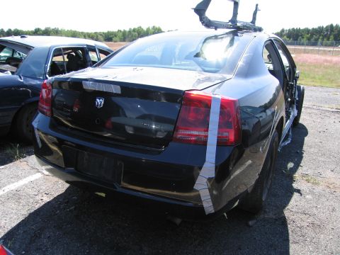 1991 Ford LTD Crown Victoria - Rear view of a black Dodge Charger, showing damage and repairs with duct tape.