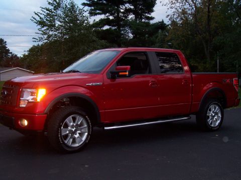 1978 Ford F-150 - This red pickup truck features a crew cab, chrome accents, and distinctive alloy wheels, captured in a three-quarter front view.